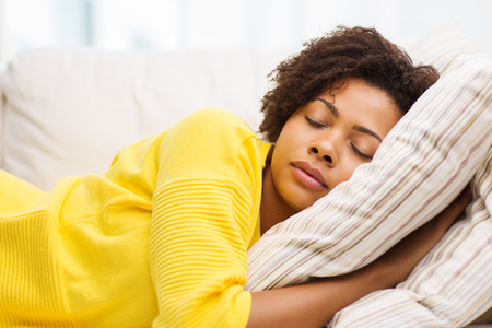 power-nap - 53856905 - people, rest, comfort and leisure concept - african american young woman sleeping on sofa at home