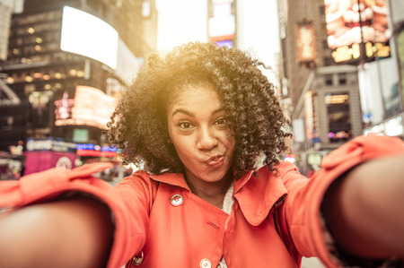 50428377 - young american woman taking selfie in new york, time square