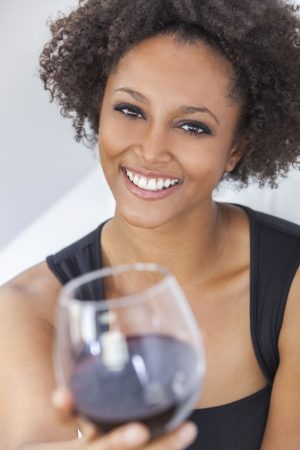 Will You Be My Valentine? 65707932 - a beautiful happy mixed race african american girl or young woman wearing a black dress and drinking red wine at home