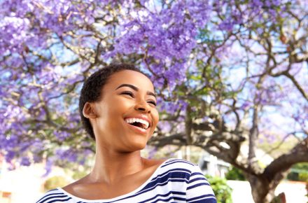 Refresh your life with a good spring clean 71517809 - portrait of attractive young black woman laughing outdoors by flower tree