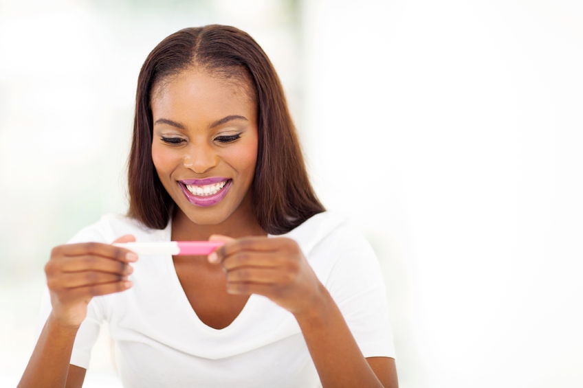 One miscarriage, one frozen embryo transfer, three IVF Cycles: My five-year journey to motherhood - 22377579 - happy afro american woman looking at pregnancy test