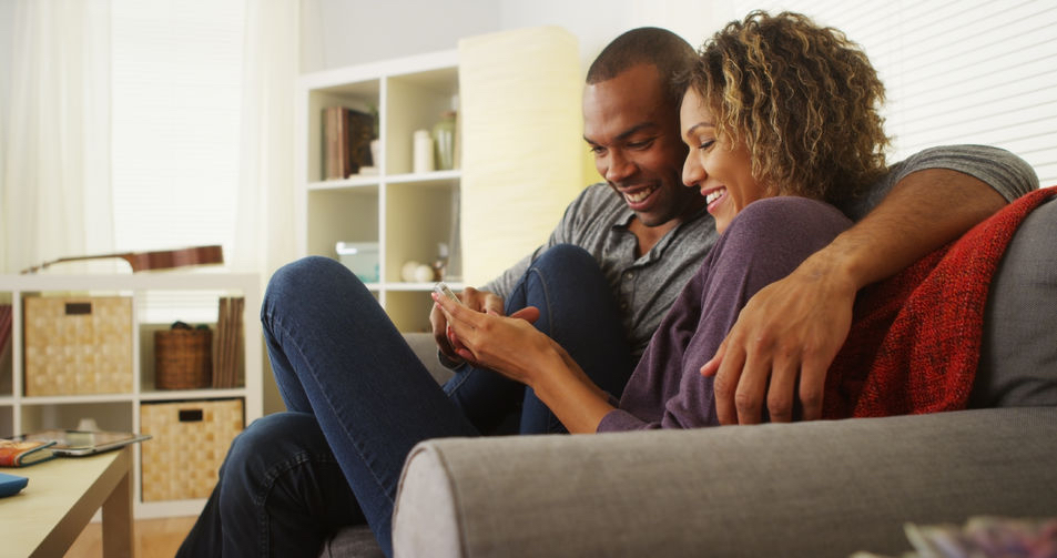 33805927 - black couple using smartphone together on couch Apps to help your love life: Infographic