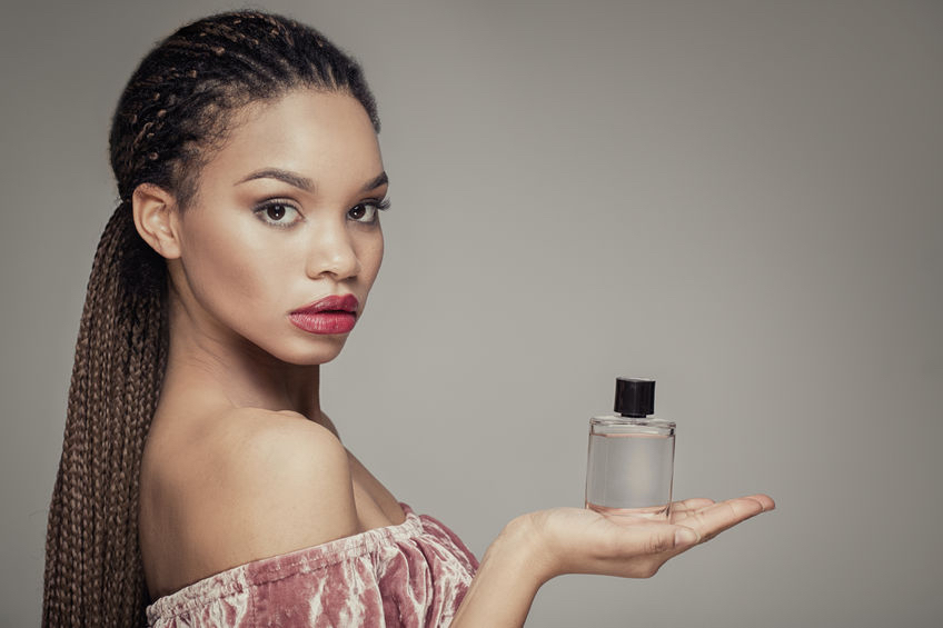 Whose scent is it anyway? - 70739566 - beauty portrait of young african american girl holding bottle of perfume, looking at camera. 