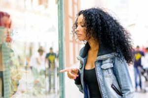17658109 - portrait of an attractive black woman, afro hairstyle, looking at the shop window
