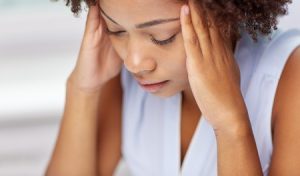 58626926 - people, emotions, stress and health care concept - unhappy african american young woman touching her head and suffering from headache