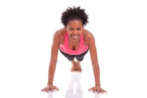 body shock - 18126036 - young beautiful african fitness woman doing push up exercises on floor,isolated on white background