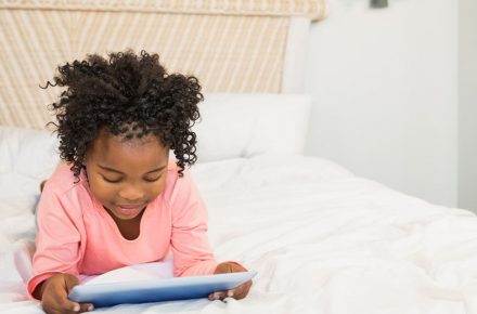 48149968 - young girl using tablet on bed at home “Put down the iPad and go play outside” say parents to tech-obsessed kids