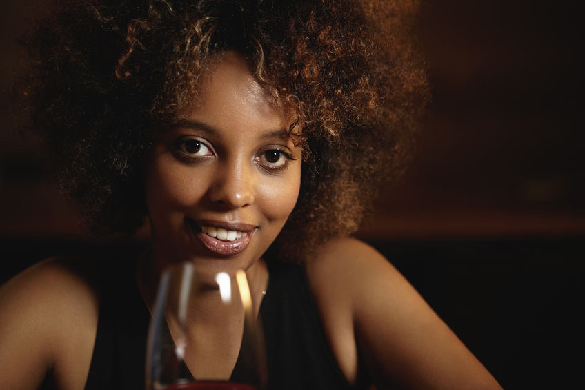 63035657 - people and leisure. attractive african female with mysterious smile and healthy shiny skin, holding glass of red wine, sitting against wooden wall background with copy space for your content Seven Alternative things to do in London this Valentine's Day